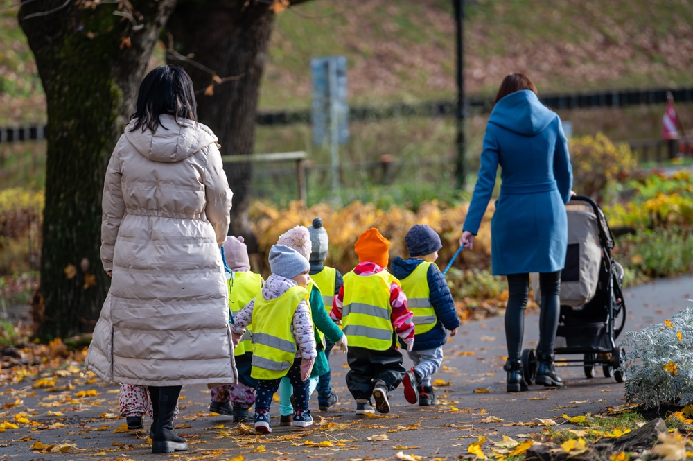 gro-up kinderen groepje loopt onder begeleiding twee volwassenen