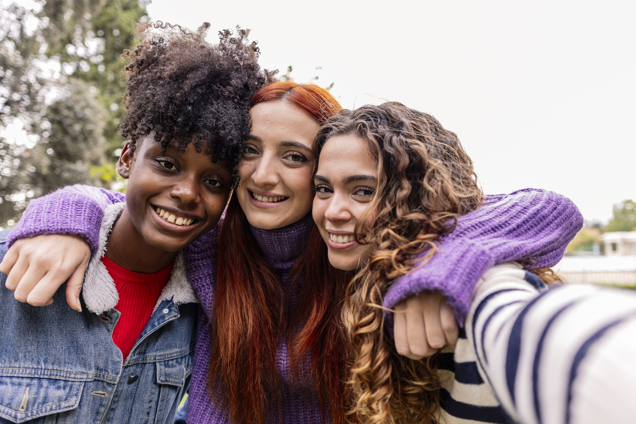 Drie tienermeisjes uit Oosterflank omhelzen elkaar op een selfie