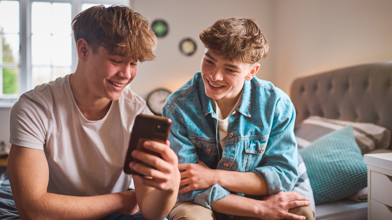 gro-up jeugd twee jongens kijken op mobiele telefoon