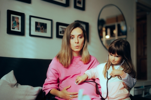 gro-up kind met stethoscoop luistert naar zwangere moeder