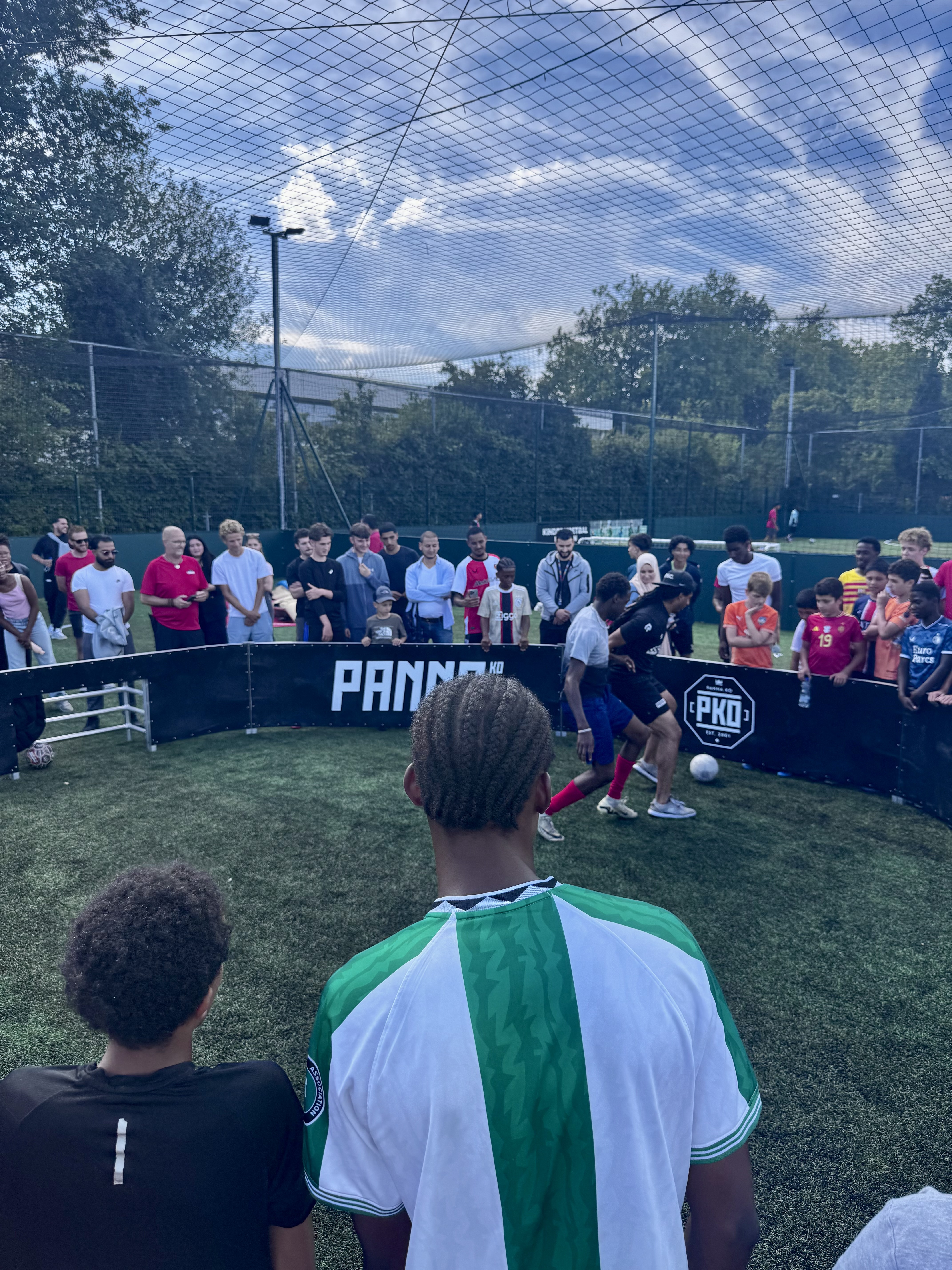 Jongeren kijken toe bij de pannakooi tijdens de gro-up buurtwerkcup 2025