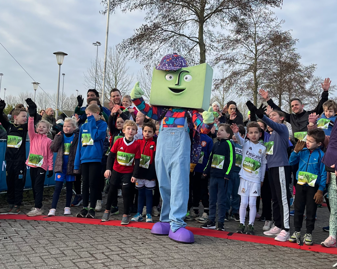 Kinderen, hun ouders en mascotte grup staan klaar bij de start van de gro-up Kids Run tijdens de Lansingerland Run 2025