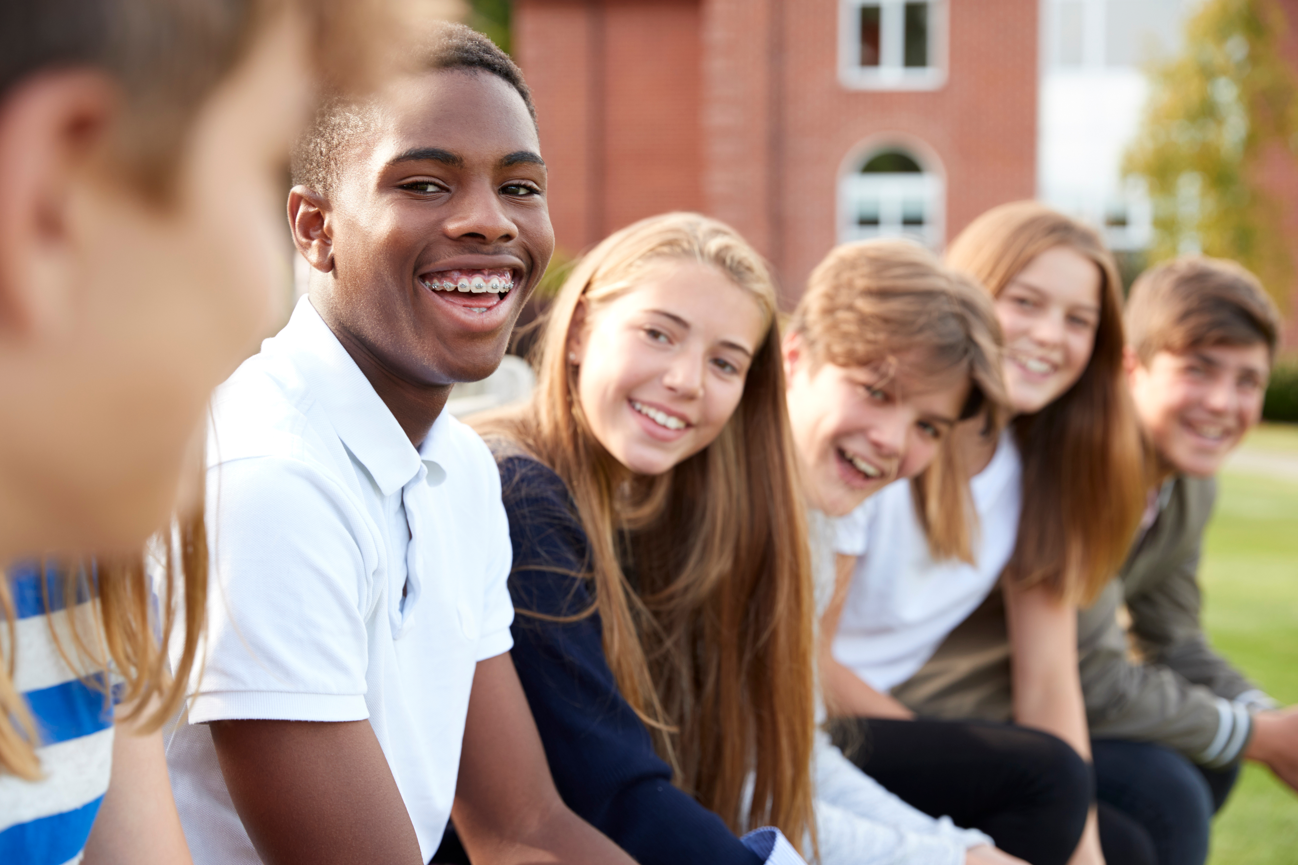 Schoolkinderen zitten lachend op een rijtje
