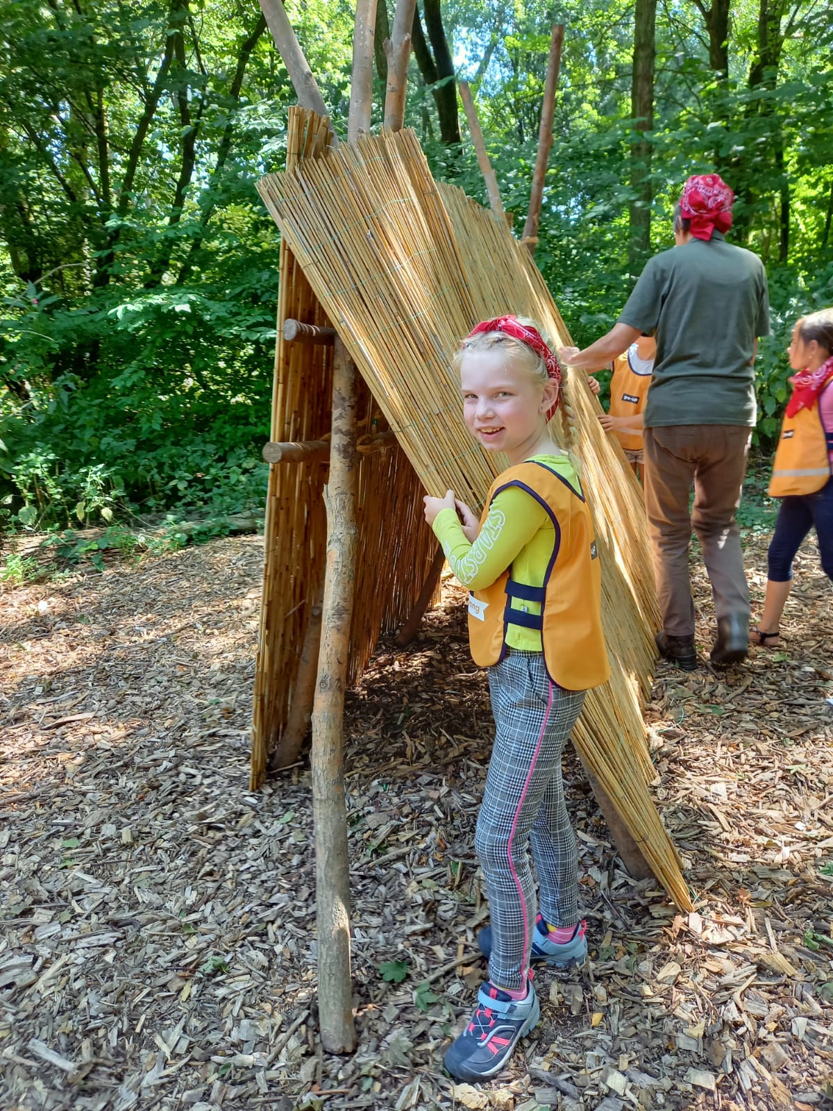 gro-up meisje bouwt een hut tijdens de campingweek