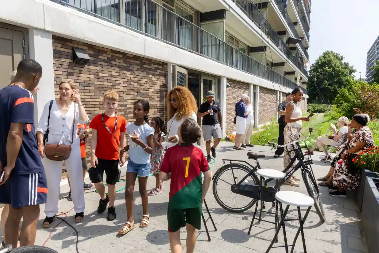 Buurtbewoners verzamelen buiten bij de opening van de SterrenHub