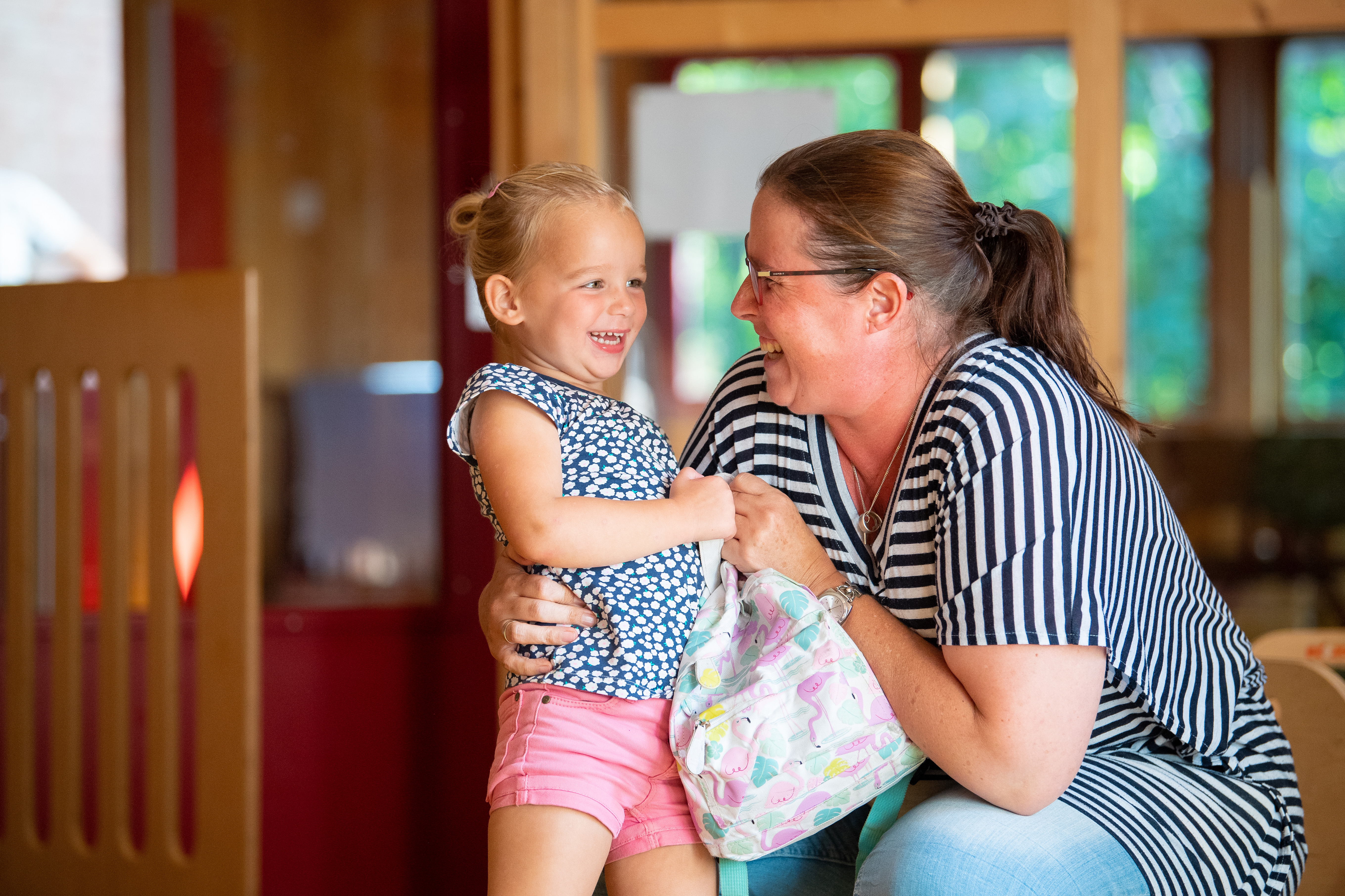 gro-up kind lacht met pedagogisch medewerker