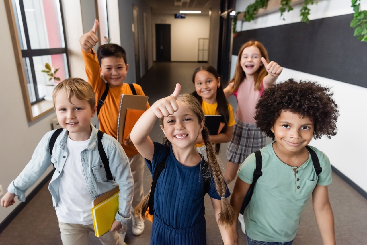 Blije schoolkinderen lopen door de gang