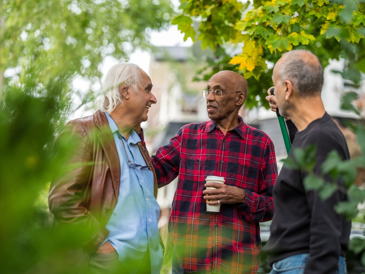 Drie mannen kletsen met elkaar in een Zoetermeerse buurt
