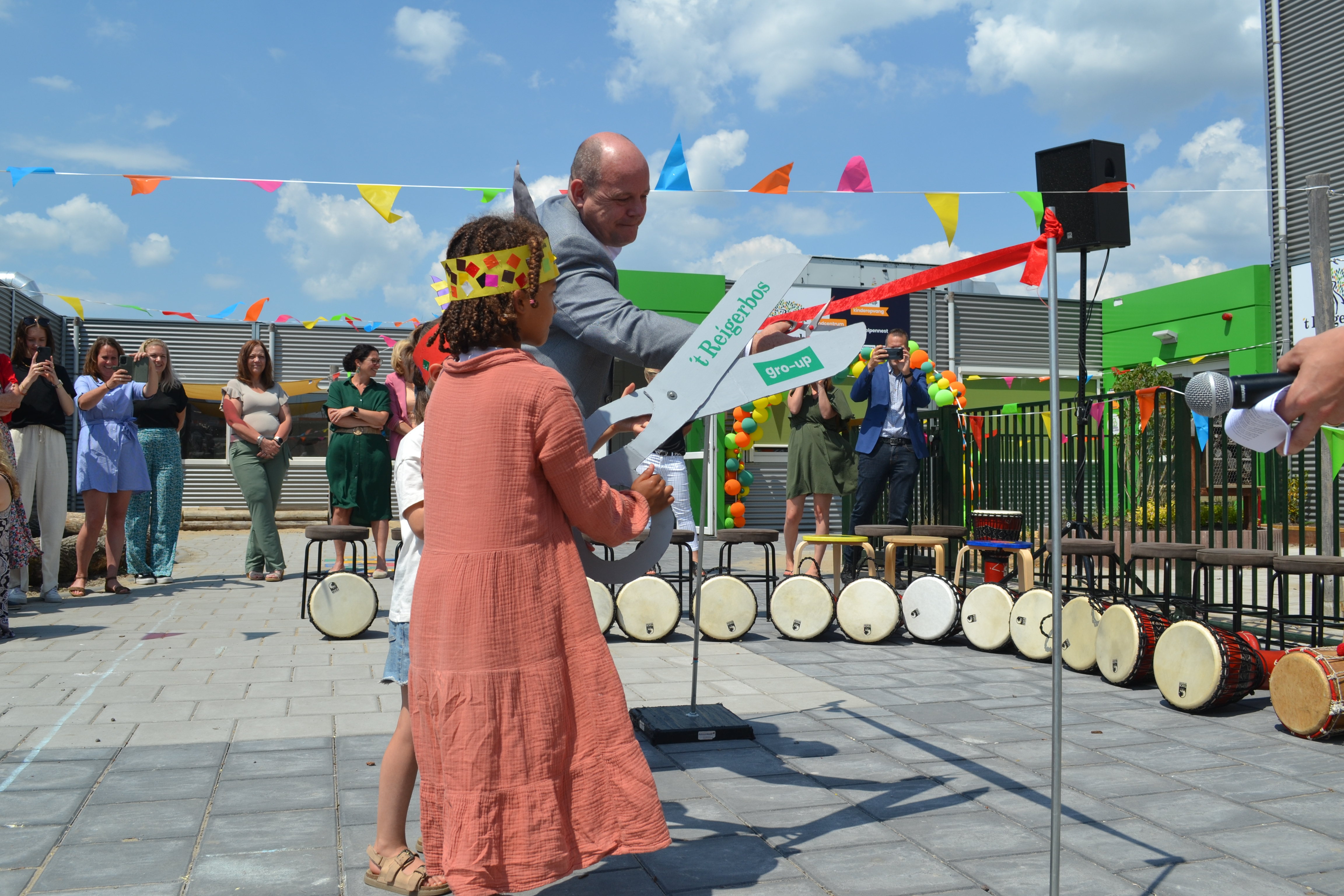 gro-up kinderen knippen lintje door bij de opening van het Kindcentrum