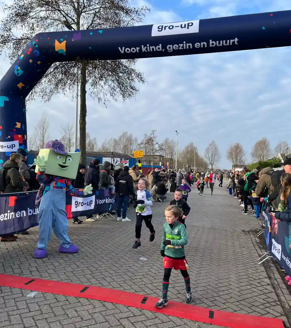 Mascotte grup ontvangt kinderen aan de finish van de gro-up Kids Run tijdens de Lansingerland Run 2025