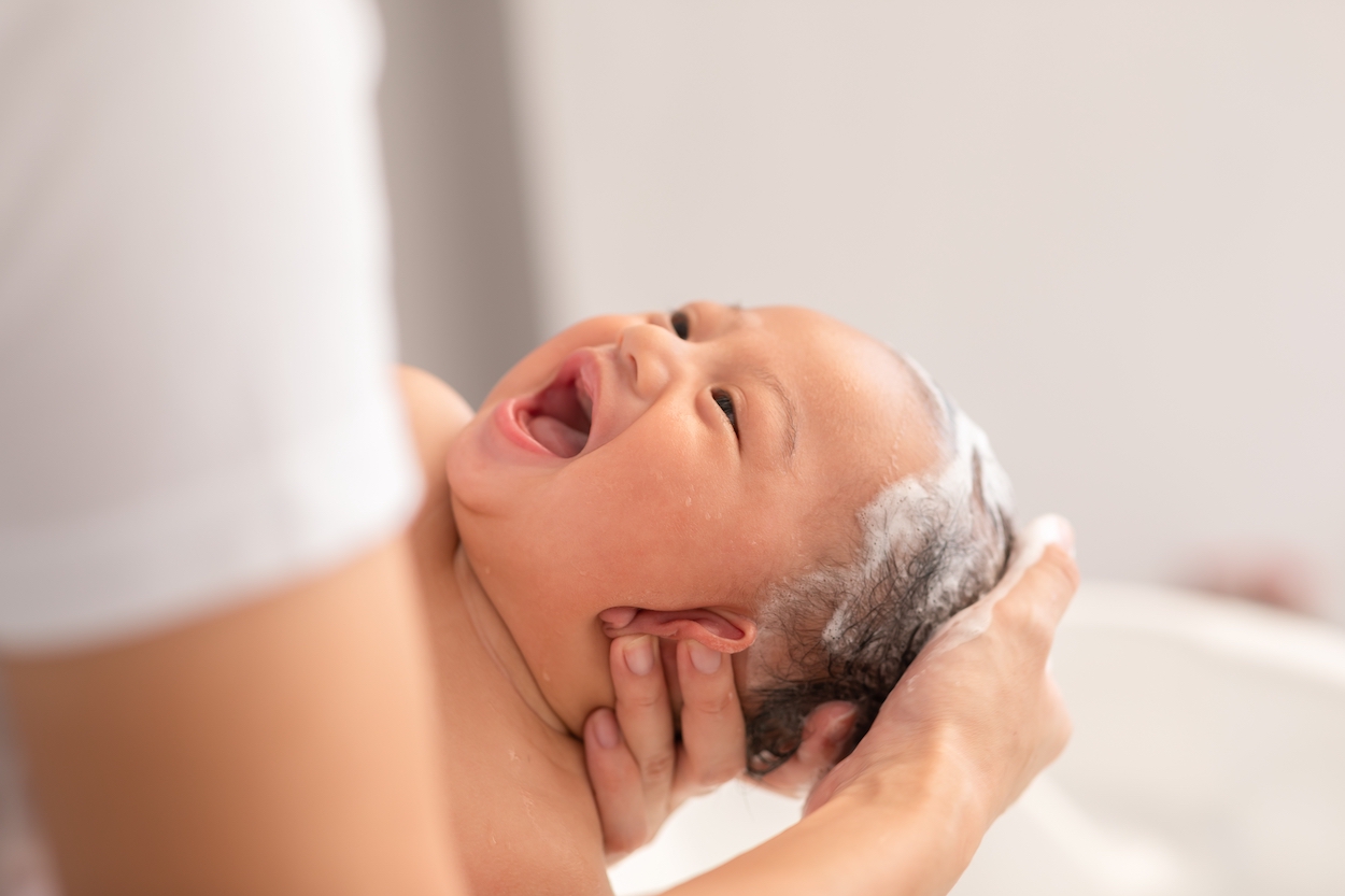 gro-up baby wordt gewassen door een kraamverzorgende
