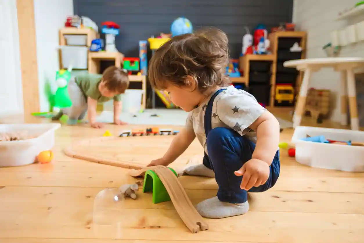 Meisje en jongen (baby-dreumes) spelen met houten trein
