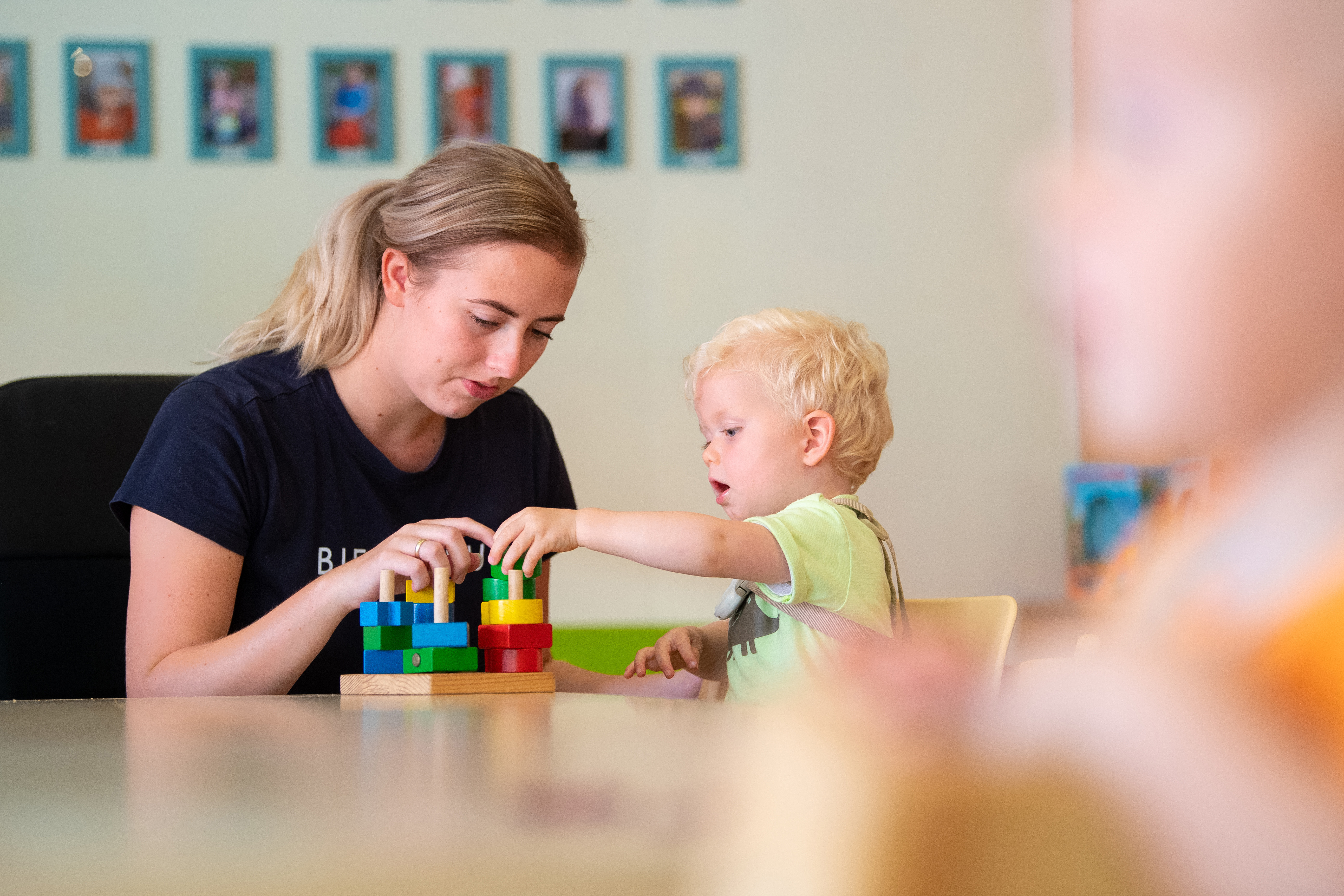 gro-up kind peuter speelt met blokken met pedagogisch medewerker