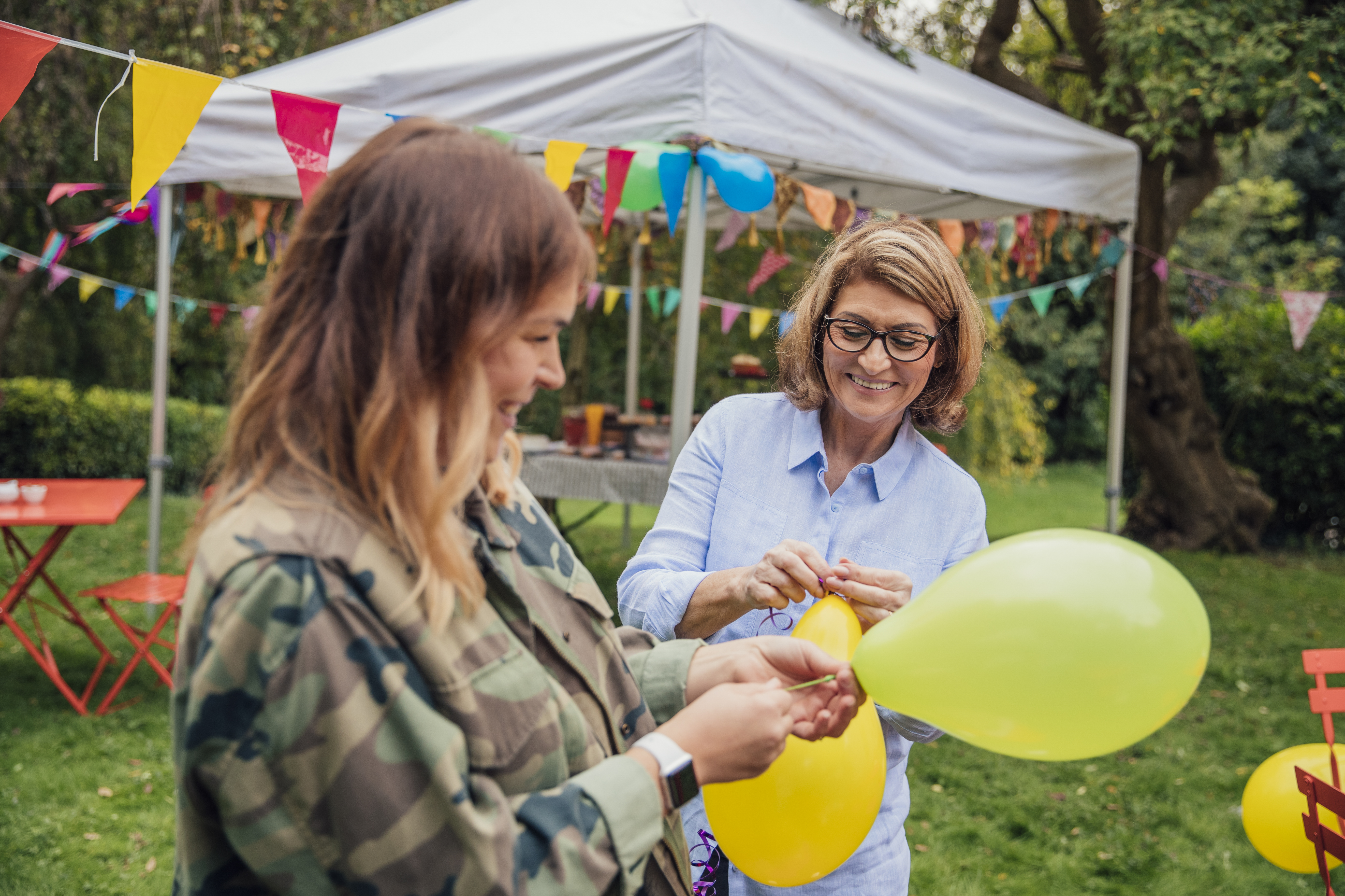 Twee dames knopen ballonnen bij elkaar voor een buurtfeest georganiseerd met Lokaal Budget van gro-up buurtwerk