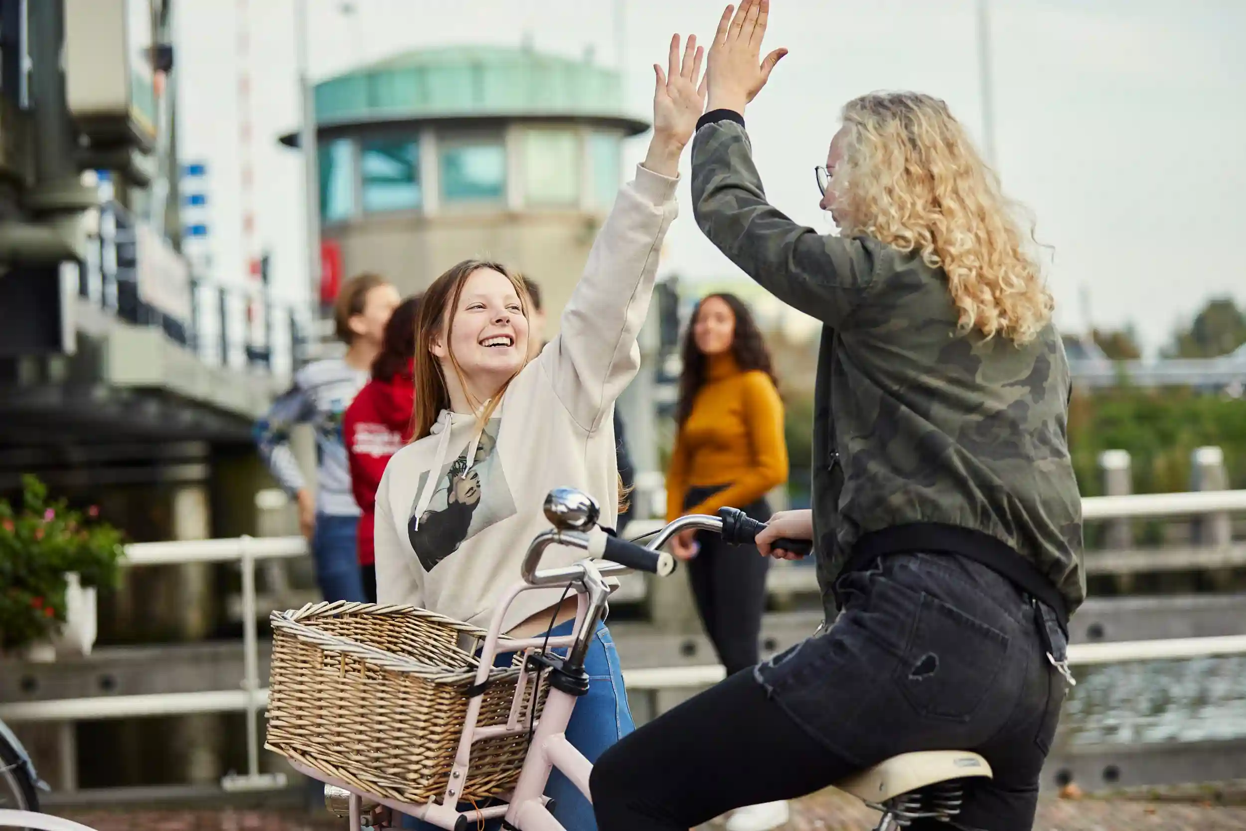 High five tussen twee meisjes die elkaar ontmoeten bij De Steigers in Schiedam Groenoord van gro-up buurtwerk