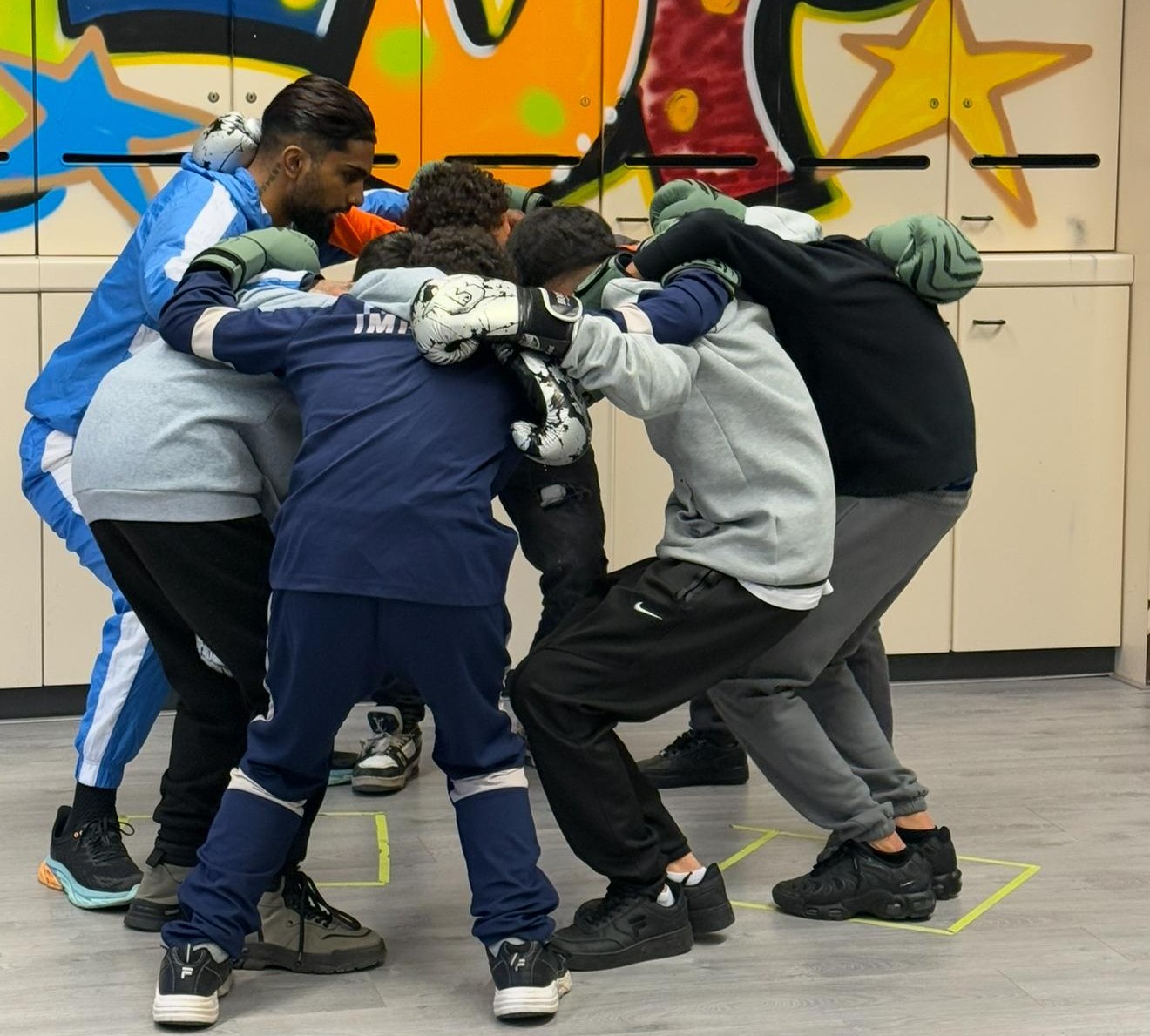 Jongeren staan in een kring voor een bokstraining van Go & Grow van gro-up buurtwerk