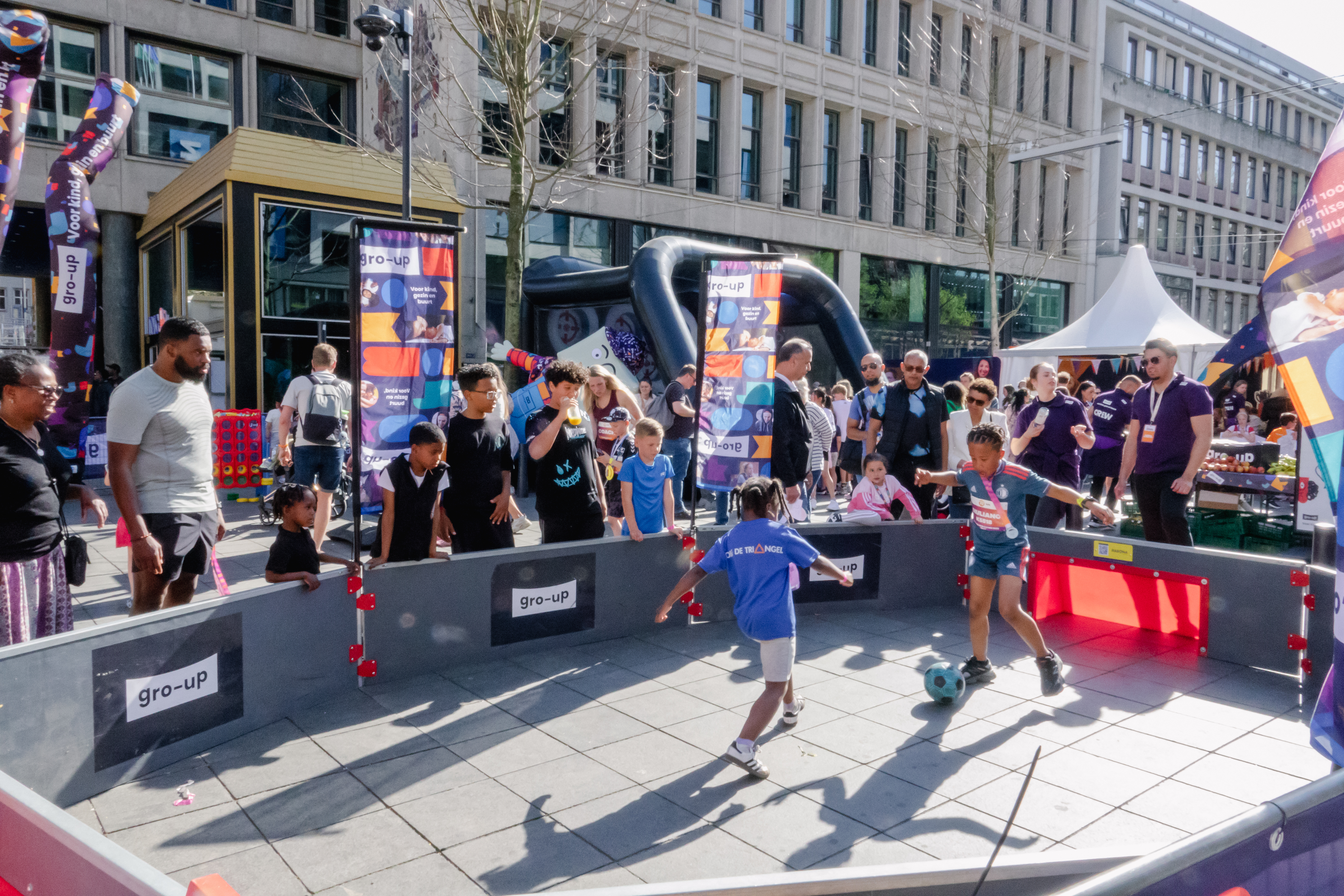 Kinderen voetballen in de pannakooi van de kids corner tijdens de NN Kids Run van de Marathon Rotterdam