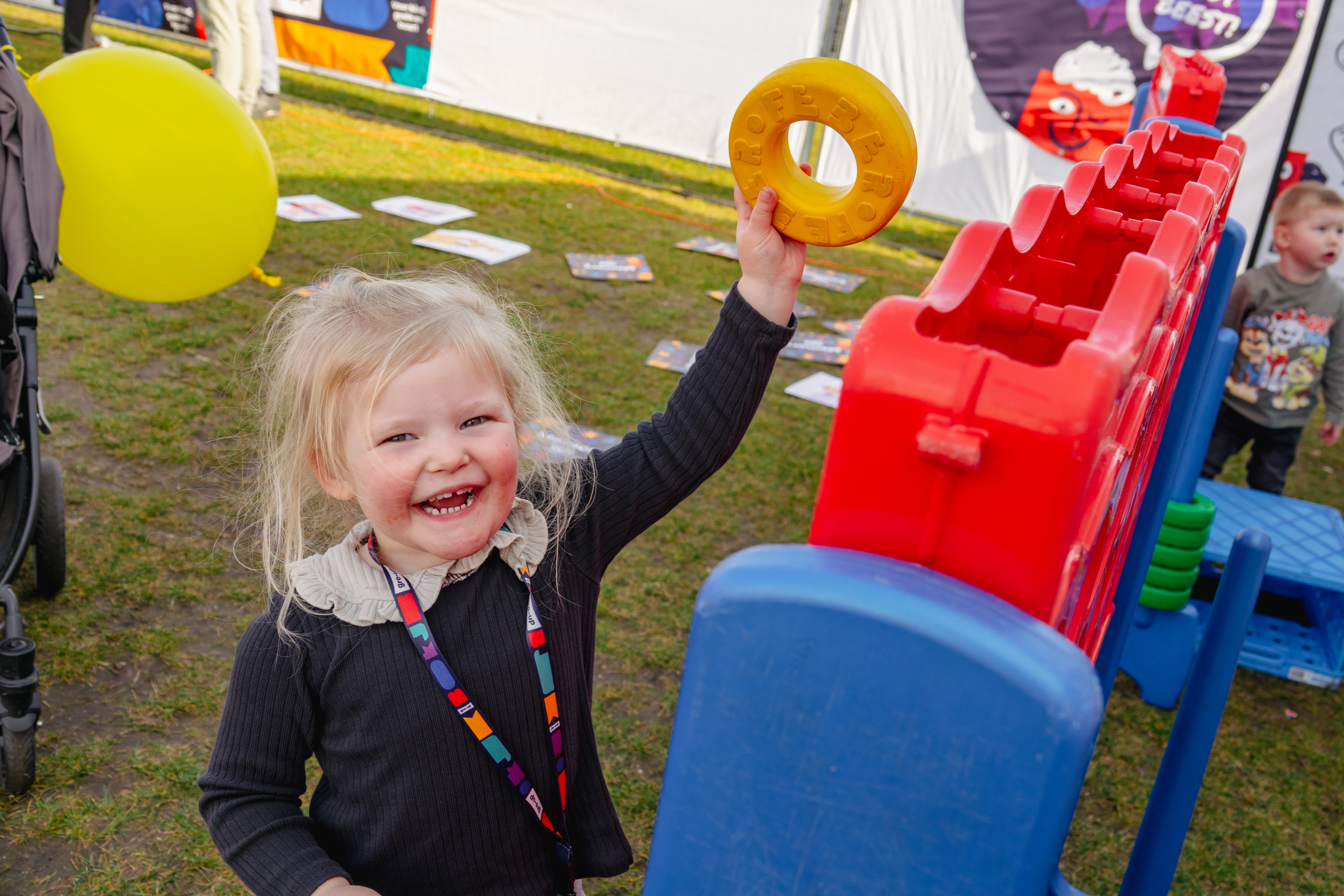 Een meisje speelt reuze vier-op-een-rij bij de kids corner tijdens de gro-up Jeugdlopen van de CPC Loop Den Haag