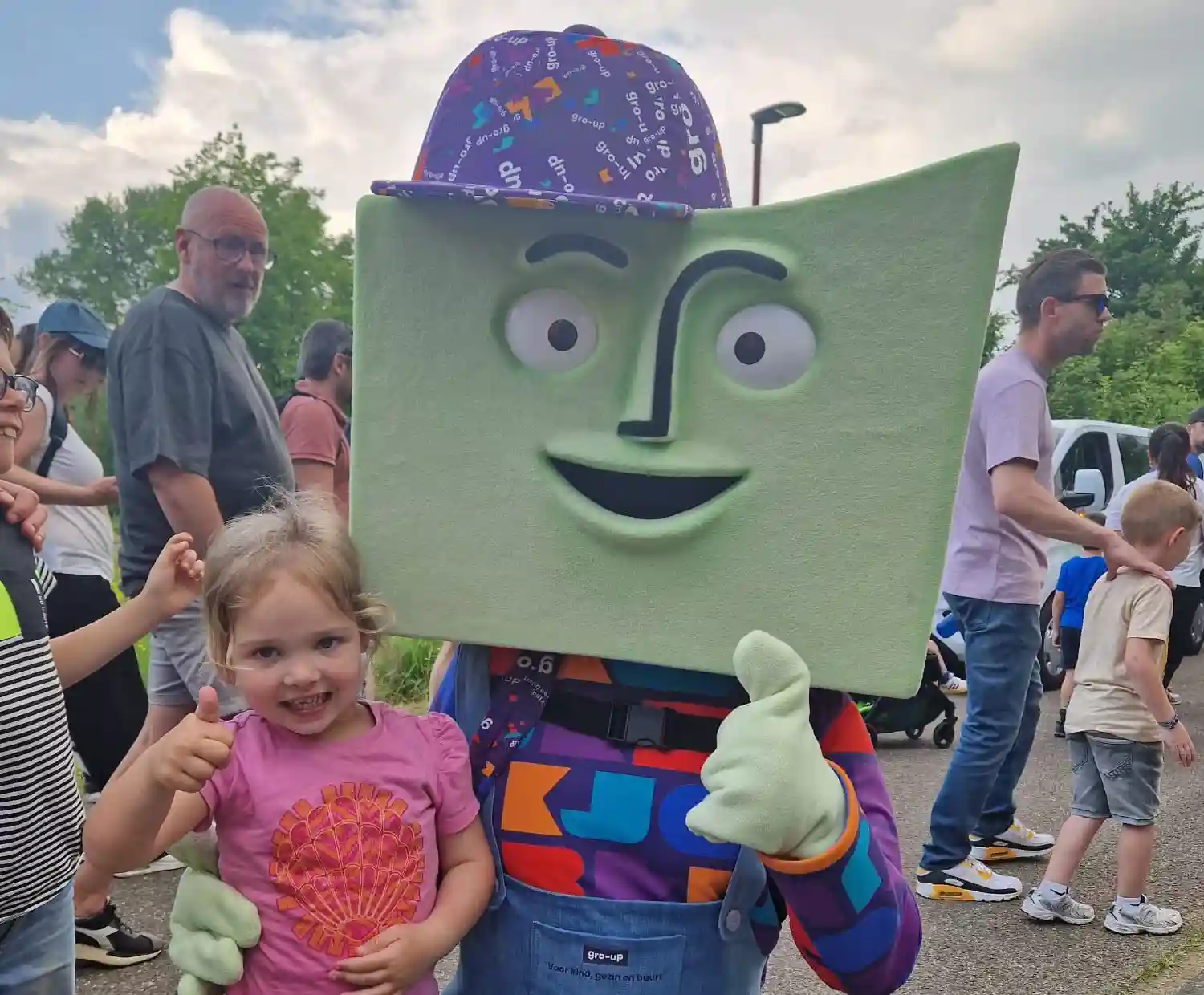 grup, de mascotte van gro-up, poseert met een kind tijdens de Avondvierdaagse in Zoetermeer
