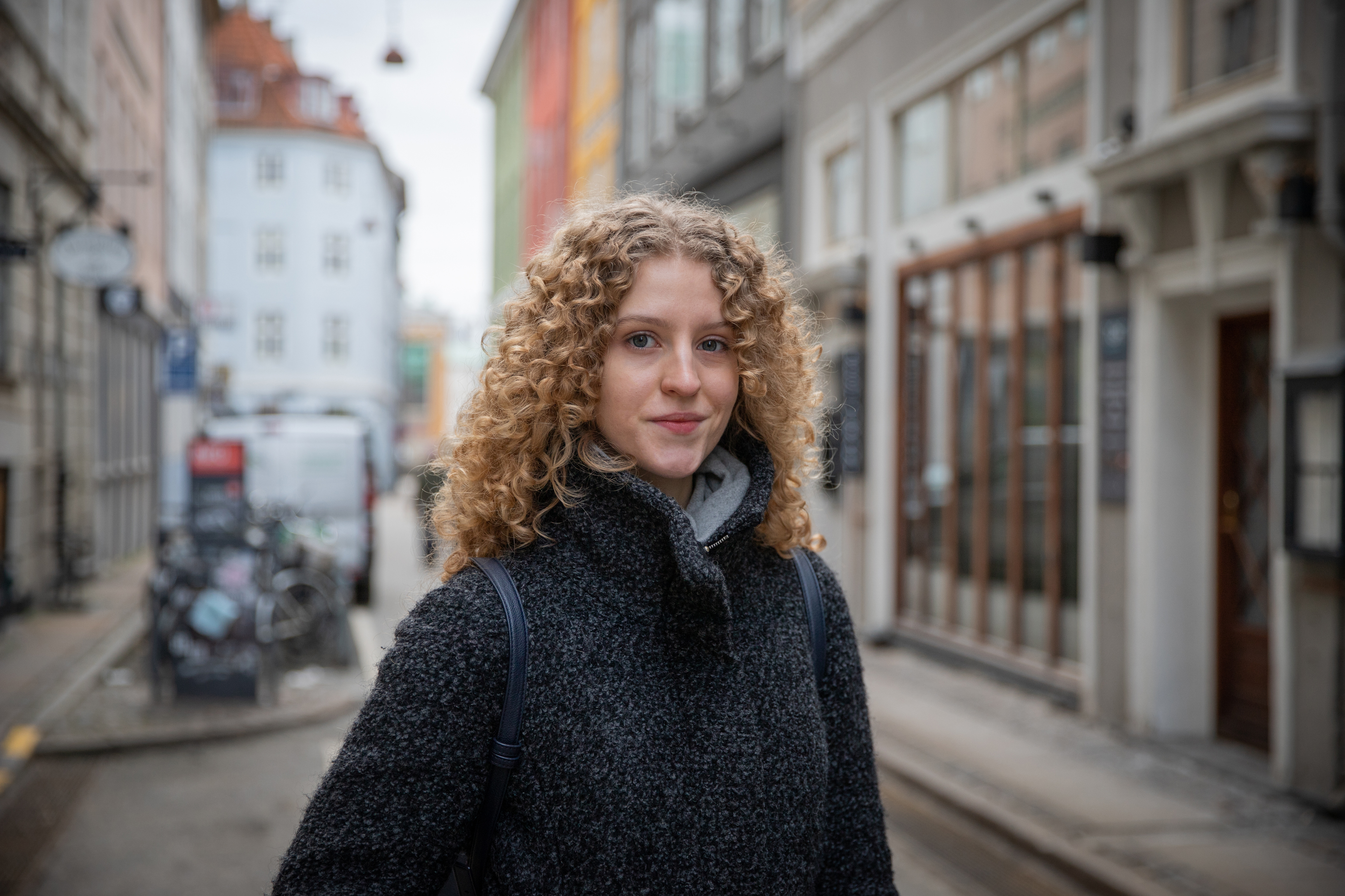 Meisje met blonde krullen poseert op straat in Waddinxveen