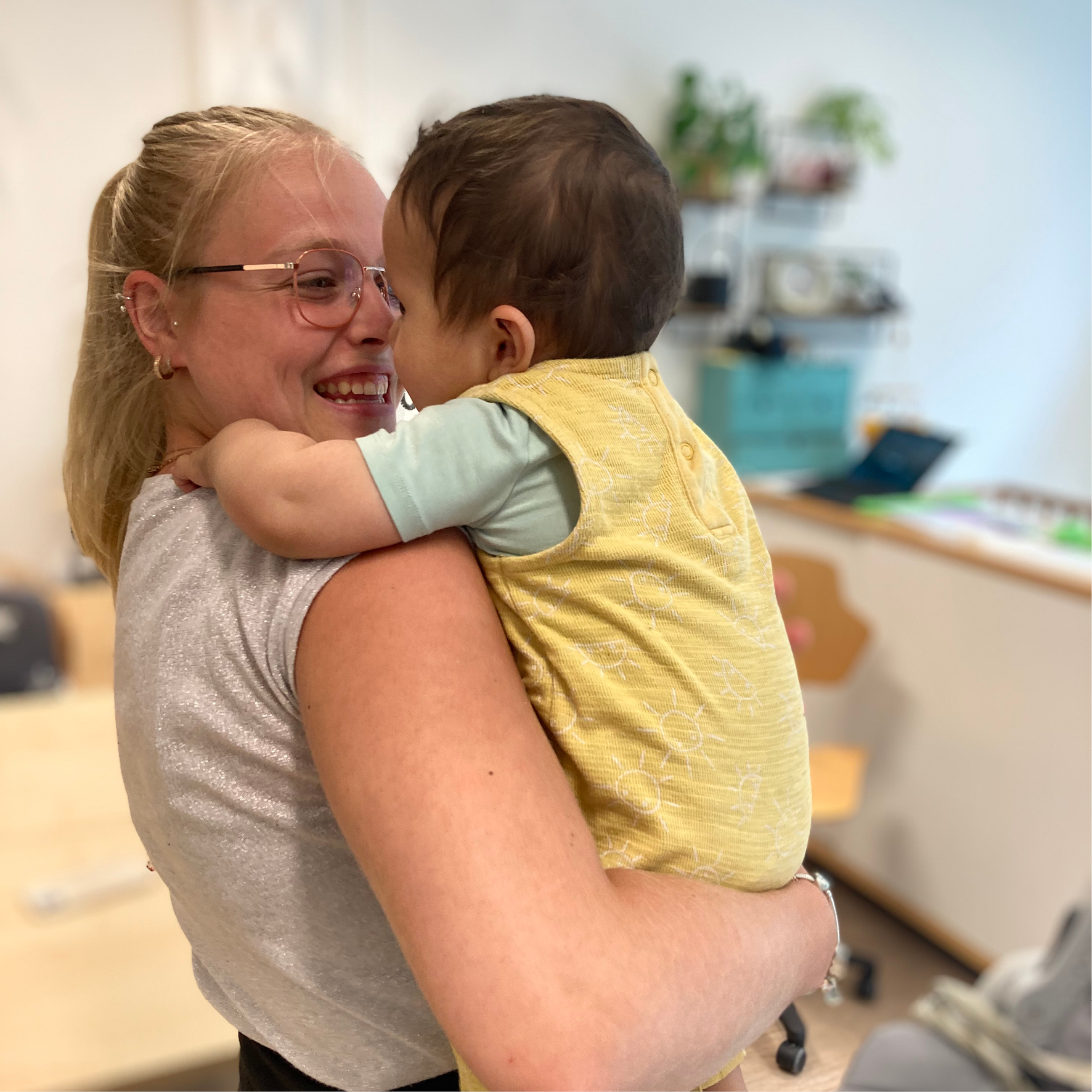 gro-up medewerker samen met baby op het kinderdagverblijf