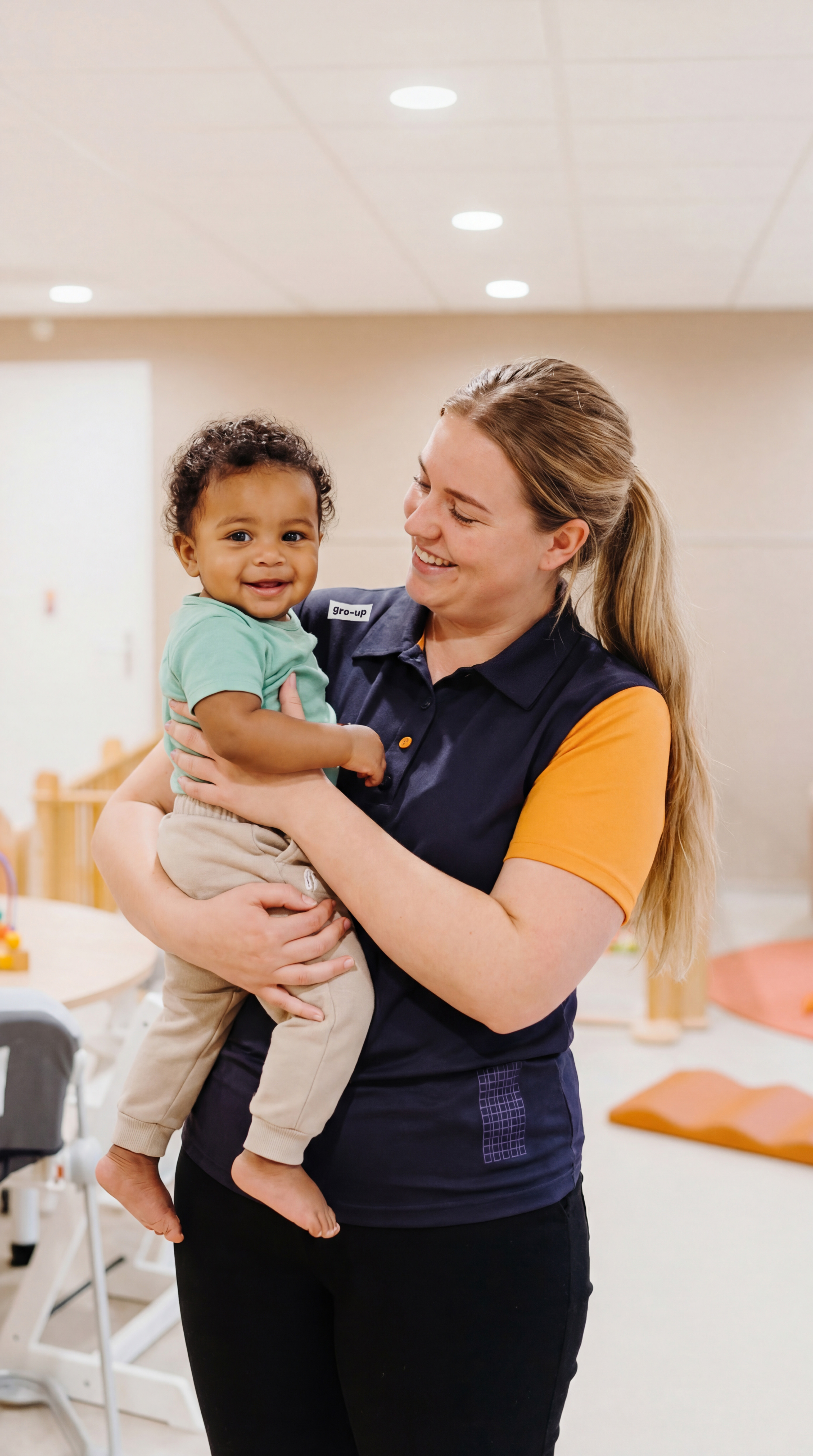 gro-up kinderdagverblijf in collega houd baby vast